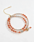 Handcrafted crystal bracelet with peach, gray beads, gold chain, and butterfly charm for positive energy