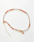 Handcrafted crystal bracelet with orange and gray beads, gold butterfly charm, and adjustable chain for positive energy.