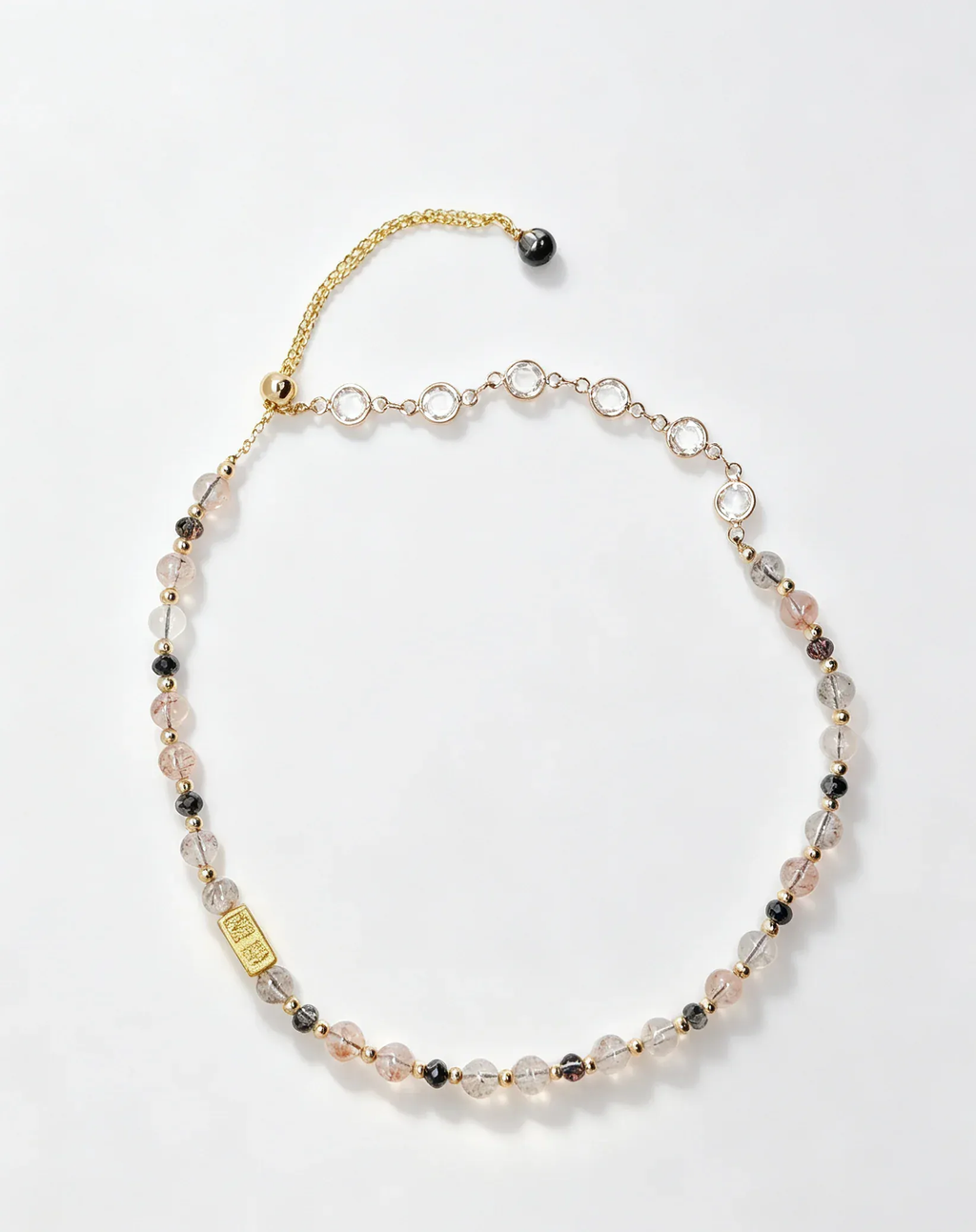 Handcrafted natural crystal necklace with pink, clear, and black beads, gold chain, and healing gemstone charm