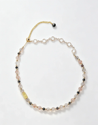 Handcrafted natural crystal necklace with pink, clear, and black beads, gold chain, and healing gemstone charm