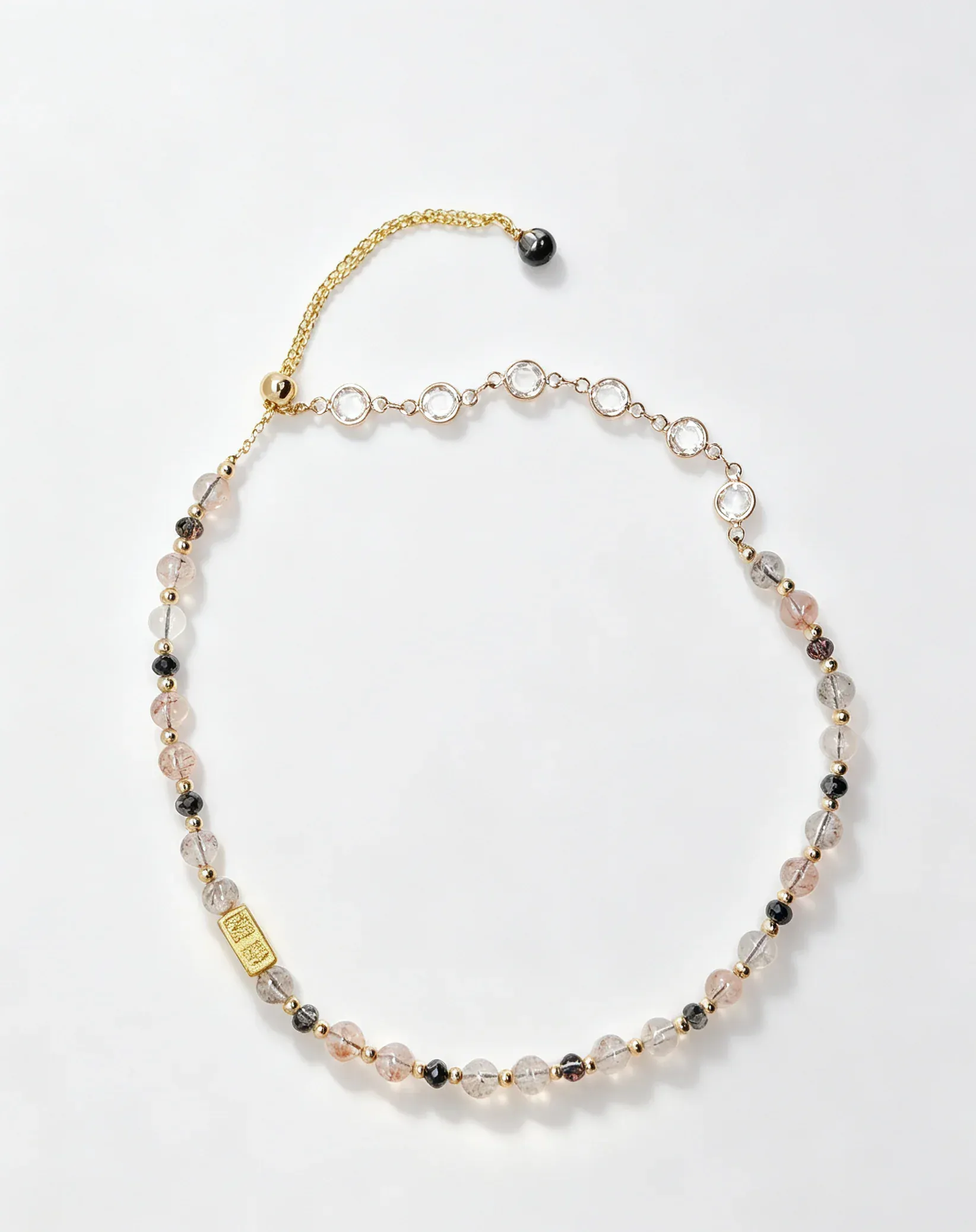 Handcrafted natural crystal necklace with pink, clear, and black beads, gold chain, and healing gemstone charm
