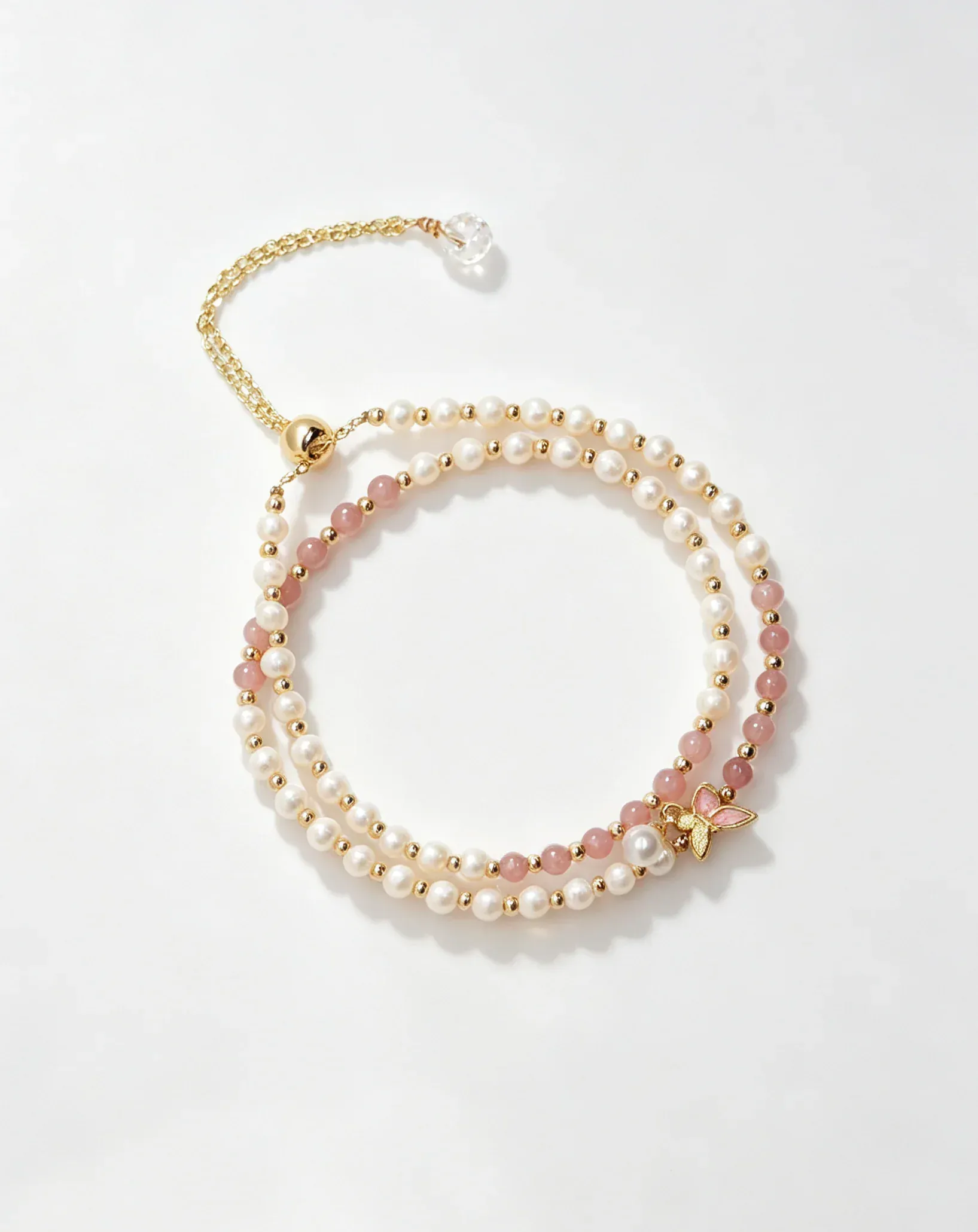 Layered pearl and pink crystal bracelet with gold butterfly charm, natural gemstone accessory for women