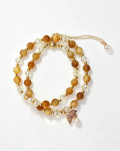 Handcrafted crystal bracelet with amber beads, clear crystals, gold accents, and a butterfly charm for positive energy.