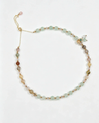 Handcrafted natural crystal bracelet with green, pink, and gold beads, featuring a dragonfly charm for positive energy.