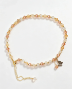 Handcrafted crystal bracelet with peach and clear beads, gold accents, and butterfly charm for positive energy